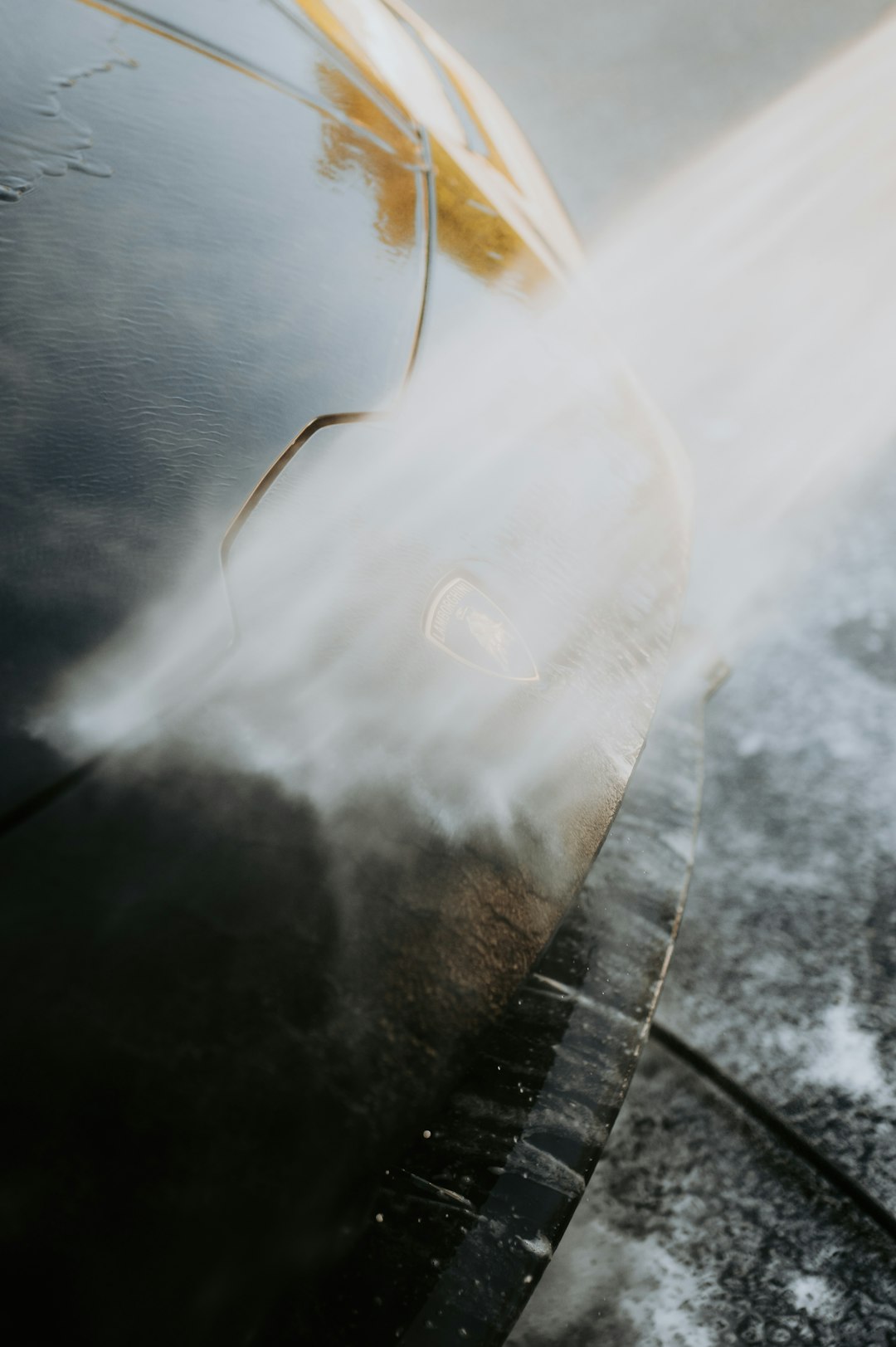 a-car-is-being-sprayed-with-water-from-a-hose-8cjxdsunqnu